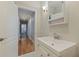 Bright bathroom features a white vanity, medicine cabinet, and hallway view at 3512 W Santiago St, Tampa, FL 33629