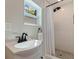Bathroom with white sink, vanity, window, shower with dark fixtures at 3512 W Santiago St, Tampa, FL 33629