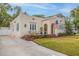 Charming stucco home featuring arched entryway, an American flag, and colorful landscaping at 3512 W Santiago St, Tampa, FL 33629