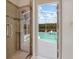 Modern bathroom with glass-enclosed shower and view of the screened pool area at 4301 Ridgemoor N Dr, Palm Harbor, FL 34685