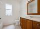 Bathroom with wood vanity, white tile flooring, and a frosted window for natural light at 4301 Ridgemoor N Dr, Palm Harbor, FL 34685