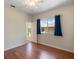 Bedroom with wood laminate flooring, ceiling fan and window with blue curtains overlooking exterior at 4301 Ridgemoor N Dr, Palm Harbor, FL 34685
