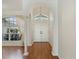 Inviting foyer with laminate flooring, decorative columns, and a double-door entrance at 4301 Ridgemoor N Dr, Palm Harbor, FL 34685