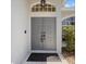 Close-up of the front door featuring a decorative window and tiled entryway at 4301 Ridgemoor N Dr, Palm Harbor, FL 34685