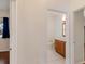 Hallway view showing bathroom featuring wood vanity with white tile flooring at 4301 Ridgemoor N Dr, Palm Harbor, FL 34685