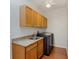 Functional laundry room with overhead cabinets, sink with granite countertop, and modern appliances at 4301 Ridgemoor N Dr, Palm Harbor, FL 34685