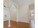 Living room featuring arched entryway, wood laminate flooring, and white accents at 4301 Ridgemoor N Dr, Palm Harbor, FL 34685