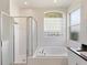 Well lit bathroom with glass block window, separate shower, and bathtub at 4301 Ridgemoor N Dr, Palm Harbor, FL 34685