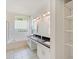 A bright main bathroom featuring double vanities, tile flooring, and a separate tub and shower at 4301 Ridgemoor N Dr, Palm Harbor, FL 34685