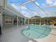 A luxurious private swimming pool with a screened enclosure and lush landscaping in the backyard at 4301 Ridgemoor N Dr, Palm Harbor, FL 34685