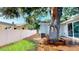 Stunning backyard features mature tree with a built-in bench, a wooden deck, and a well-maintained lawn at 4530 5Th S Ave, St Petersburg, FL 33711
