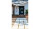Close-up of a home's modern black front door and inviting wooden porch with planters at 4530 5Th S Ave, St Petersburg, FL 33711