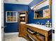 Elegant bathroom featuring a wood vanity, blue walls, marble countertop, and decorative accents at 4803 Longwater Way, Tampa, FL 33615
