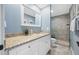 Updated bathroom with granite countertops, soft blue walls, and tiled walk-in shower at 4803 Longwater Way, Tampa, FL 33615