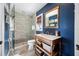 Bathroom featuring blue walls, a glass shower, and a wooden vanity with a marble countertop at 4803 Longwater Way, Tampa, FL 33615