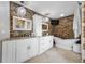 Modern bathroom with stone accent wall, white cabinetry, granite counters, and freestanding tub at 4803 Longwater Way, Tampa, FL 33615