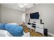 Light-filled bedroom with wood floors, modern furniture and large wall-mounted television at 4803 Longwater Way, Tampa, FL 33615