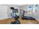 Bright exercise room with wood floors, cardio equipment, and natural light from arched window at 4803 Longwater Way, Tampa, FL 33615