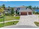 Beautiful home with a three-car garage, lush landscaping, and a brick paver driveway at 4803 Longwater Way, Tampa, FL 33615