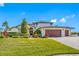 Charming two-story home featuring manicured landscaping, a paver driveway, and a three-car garage at 4803 Longwater Way, Tampa, FL 33615