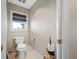 Cozy powder room featuring neutral paint, toilet, and decorative accents near a window at 4803 Longwater Way, Tampa, FL 33615