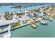 Aerial view of waterfront home with a private pool, dock, and lush landscaping on a sunny day at 512 173Rd E Ave, North Redington Beach, FL 33708