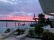 Relaxing backyard view with lounge chairs overlooking the water at sunset at 512 173Rd E Ave, North Redington Beach, FL 33708