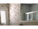 Bathroom with wallpaper, plantation shutters, and a large vanity mirror at 512 173Rd E Ave, North Redington Beach, FL 33708