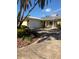 Charming yellow home with a large driveway, a two-car garage, a metal roof, and a covered front porch with rocking chairs at 512 173Rd E Ave, North Redington Beach, FL 33708
