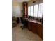 Home office featuring a built-in wooden desk with drawers and cabinets, neutral walls, and tiled floors at 512 173Rd E Ave, North Redington Beach, FL 33708