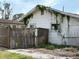 Exterior of a white home with a dilapidated fence, overgrown vines, and broken windows at 5217 18Th S Ave, Gulfport, FL 33707