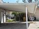 View of an outdoor carport with an adjacent shed and junk items on the lot at 5217 18Th S Ave, Gulfport, FL 33707