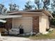 Exterior view of a garage with a roll-up door and discarded furniture next to a brick wall at 5217 18Th S Ave, Gulfport, FL 33707