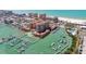 Breathtaking aerial view of a waterfront community with a marina, beach, and high-rise buildings at 525 Mandalay Ave # 33, Clearwater Beach, FL 33767