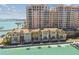 Stunning aerial view of luxury condos and townhouses along the waterfront with lush landscaping, and boat docks at 525 Mandalay Ave # 33, Clearwater Beach, FL 33767