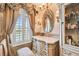 Bathroom with an ornate vanity, shuttered window, and decorative mirror at 525 Mandalay Ave # 33, Clearwater Beach, FL 33767