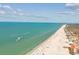 Aerial view of pristine beach with clear water, white sand, and speed boats at 525 Mandalay Ave # 33, Clearwater Beach, FL 33767