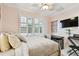 Comfortable bedroom with a ceiling fan, window shutters, and a sleek, wall-mounted television at 525 Mandalay Ave # 33, Clearwater Beach, FL 33767