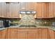 Kitchen with modern stainless appliances, sleek cooktop, and wood cabinetry complemented by attractive granite counters at 525 Mandalay Ave # 33, Clearwater Beach, FL 33767