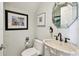 Unique powder room showcasing a decorative sink, a framed art collection, and soft lighting at 525 Mandalay Ave # 33, Clearwater Beach, FL 33767