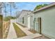 Side exterior view of the home featuring a walkway, utilities, and light green siding at 5317 Black Pine Dr, Tampa, FL 33624