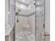 Modern walk-in shower featuring mosaic tile accents, a corner shelf, and sleek, glass doors at 5317 Black Pine Dr, Tampa, FL 33624