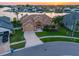 Expansive aerial view of a well-maintained home with lush landscaping, a circular driveway, and serene waterfront access at 5812 Mariners Watch Dr, Tampa, FL 33615