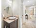 Powder room with a modern vessel sink, granite countertop, and travertine flooring with a view to the hallway at 5812 Mariners Watch Dr, Tampa, FL 33615