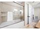 Bathroom features a bathtub with glass door, tiled walls, and travertine flooring at 5812 Mariners Watch Dr, Tampa, FL 33615