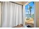 Enclosed outdoor shower features tile flooring and views of the lake and palm trees at 5812 Mariners Watch Dr, Tampa, FL 33615