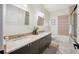 Bathroom with double sinks, granite countertop, travertine flooring, and decorative light fixture at 5812 Mariners Watch Dr, Tampa, FL 33615