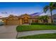 Attractive home exterior with lush landscaping, well-manicured lawn, and a welcoming entrance framed by palm trees at 5812 Mariners Watch Dr, Tampa, FL 33615