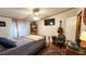Bedroom with hardwood floors, rug, television, ceiling fan, musical instruments and desk at 6051 106Th N Ave, Pinellas Park, FL 33782