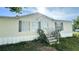 Charming home exterior with landscaped front yard, grass, and updated staircase at 6051 106Th N Ave, Pinellas Park, FL 33782